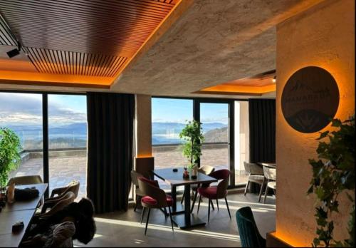 a dining room with a table and chairs and windows at Apartman D&V Milmari Resort S10 in Kopaonik