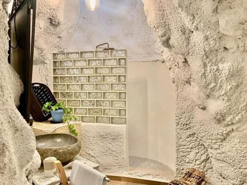baño con lavabo y pared de piedra en Vivienda Rincon de Mágina, en Bedmar