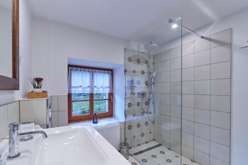 baño blanco con ducha y lavamanos en Banská Štiavnica - Apartmán 1, en Banská Štiavnica