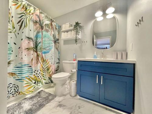 a bathroom with a toilet and a sink and a mirror at 4 Bedrooms House with Private Pool and Spa 2 Min Walk To The Beach - Zula Siesta Beach House in South Padre Island