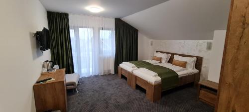 a bedroom with a bed and a television in a room at Casa Pe Vale in Râşnov