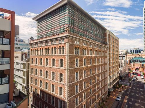 a tall brick building on a city street at Holiday Inn Darling Harbour, an IHG Hotel in Sydney