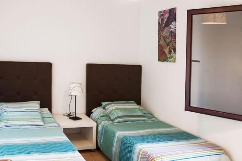 ラ・オリーバにあるCasa Acebucheのベッドルーム1室(隣り合わせのベッド2台付)