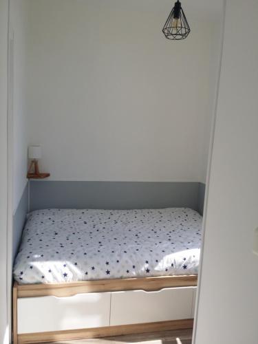Bett in einem Zimmer mit einer weißen Wand in der Unterkunft Appartement avec vue imprenable sur la montagne in Argelès-Gazost