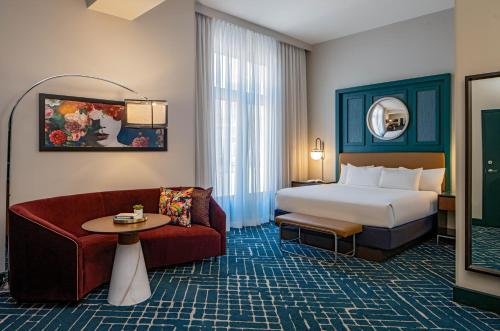 um quarto de hotel com uma cama e um sofá em Hyatt Centric French Quarter em Nova Orleães