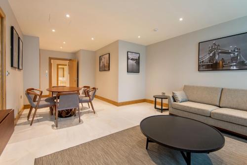 a living room with a couch and a table at Sanctum Belsize Road in London