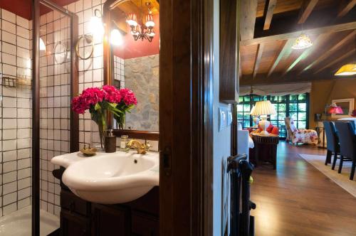 ein Badezimmer mit Waschbecken und Spiegel und ein Wohnzimmer in der Unterkunft Villa vacacional el Castañin in Pancar