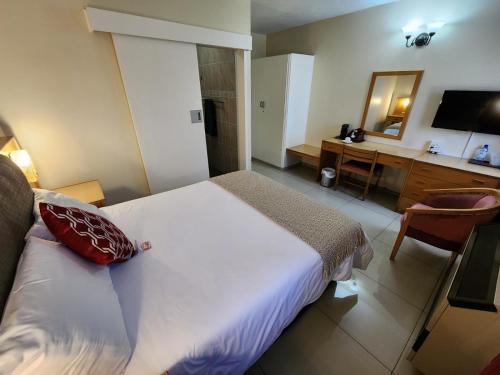 a bedroom with a bed and a desk with a mirror at Royal Hotel Ladysmith in Ladysmith