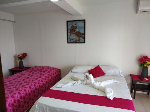 a bedroom with a bed with a pink and white blanket at Cabañas Mister Mac in Providencia