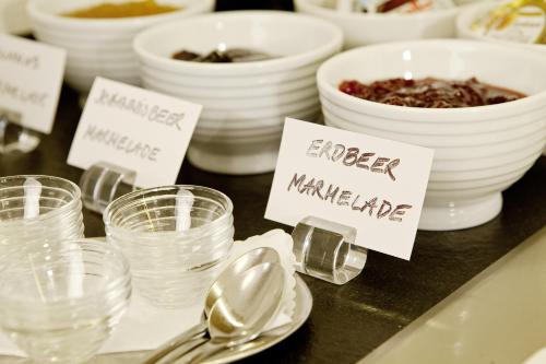 a table topped with bowls and spoons and plates of food at Gasthof Lerner in Freising