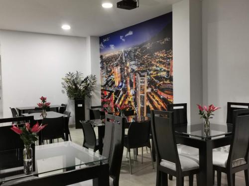 a dining room with tables and chairs and a painting on the wall at Hotel Radel Bogotá in Bogotá