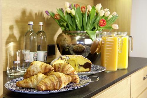 two plates of croissants and bread on a counter with flowers at Gasthof Lerner in Freising