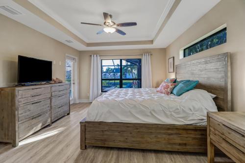 una camera da letto con un letto grande e una TV a schermo piatto di Villa Maya Serenity a Cape Coral