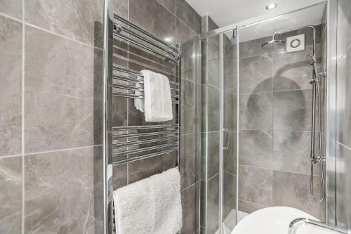 y baño con ducha, aseo y toallas. en 8 Beds Denmark House, en Norwich
