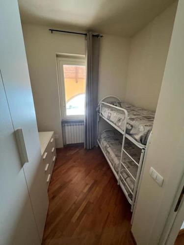 a small room with a bunk bed and a window at Villetta verde Smeraldo in Vignale Monferrato