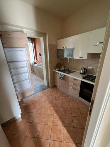 a kitchen with white cabinets and a tile floor at Villetta verde Smeraldo in Vignale Monferrato