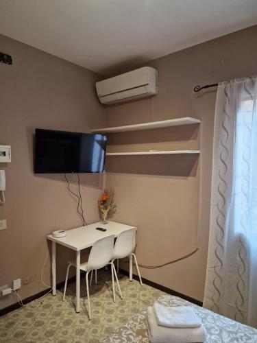 a room with a table and a tv on the wall at San Pietro Apartment in Padova