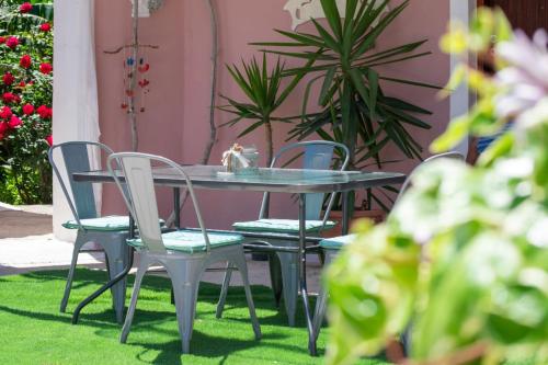 een tafel en stoelen in een tuin met planten bij Doras Beach Bungalow B in Plános