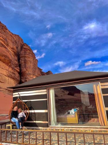 a couple of people sitting in a window of a caravan at RUM STARDUST lUXURY CAMP in Wadi Rum