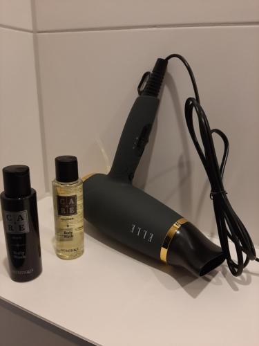 a hair dryer sitting on a counter next to a bottle of hair products at B&B De Verre Kijker in Barsingerhorn