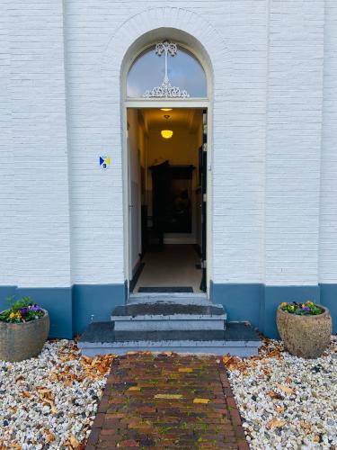 an entrance to a building with stairs and an archway at De Oude Pastorie in Bunschoten