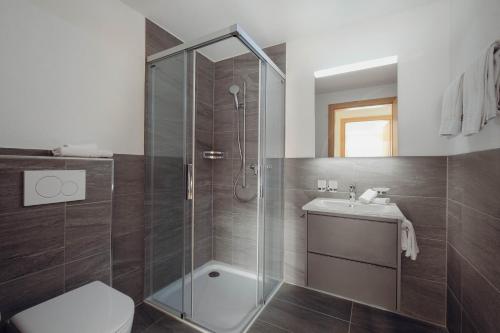 ein Bad mit einer Dusche, einem WC und einem Waschbecken in der Unterkunft Châlet Bärgfride in Kandersteg