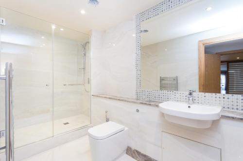 a bathroom with a toilet and a sink and a shower at Sanctum Belsize Road in London