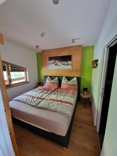 um quarto com uma cama com paredes verdes em Nockalm Appartement Hochrindl 