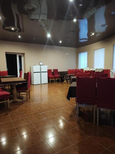 a dining room with tables and chairs and red chairs at Мотель ОК in Shepetivka