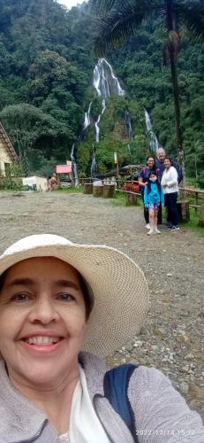 a woman wearing a hat in front of a waterfall at HOSTAL CASA VICTORIA PIJAO in Pijao