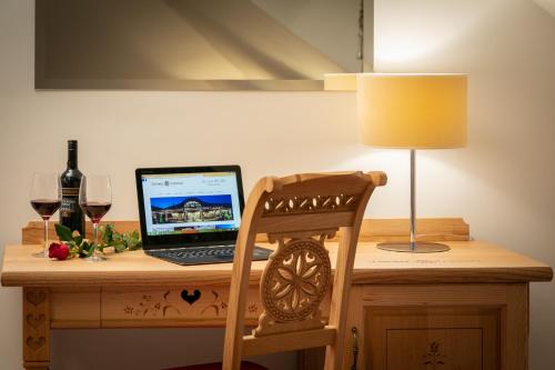 a laptop computer sitting on a wooden desk with a lamp at Dworek Góralski in Łodygowice