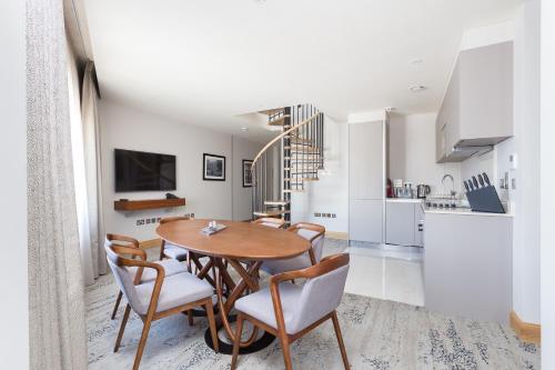 a kitchen and dining room with a wooden table and chairs at Sanctum Belsize Road in London