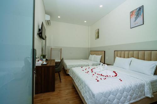 a hotel room with two beds with red flowers on it at VÂN TRANG GARDEN HOTEL 2 in Vĩnh Long