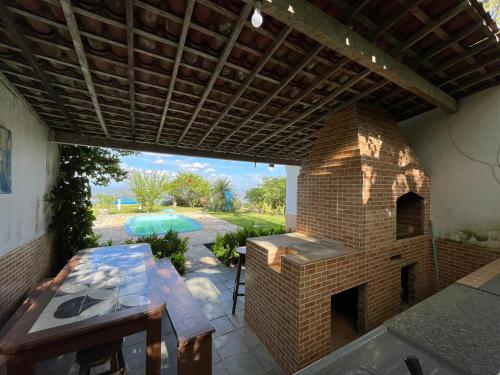 an outdoor patio with a brick oven and a table at Casa das Nuvens Taquaritinga-PE in Taquaritinga do Norte