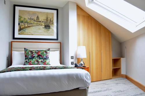 a bedroom with a bed and a painting on the wall at Sanctum Belsize Road in London