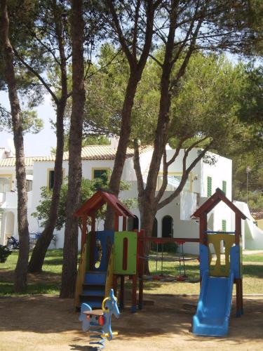 a playground in a park with trees at Apartamentos Las Brisas I & II in Cala'n Bosch