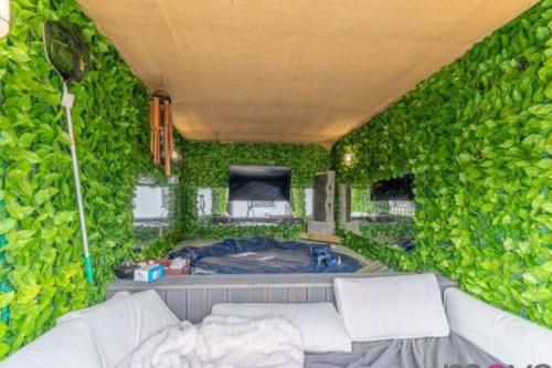 a room with a green wall with a tub in it at Modern 4 bed home, hottub and traditional pub in Down Hatherley