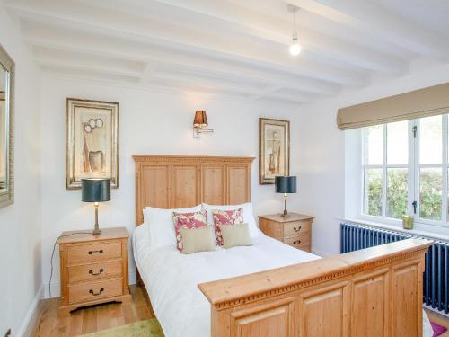 a bedroom with a large bed and two lamps at Wheelwright Cottage in Branscombe