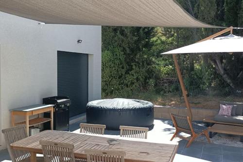 a patio with a table and a largeiameteriameteriameteriameter at Magnifique villa avec jacuzzi et billard in Limoux