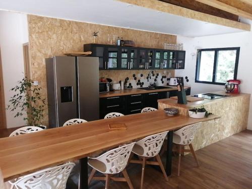 Il comprend une cuisine équipée d'une table en bois et d'un réfrigérateur. dans l'établissement Magnifique villa avec jacuzzi et billard, à Limoux