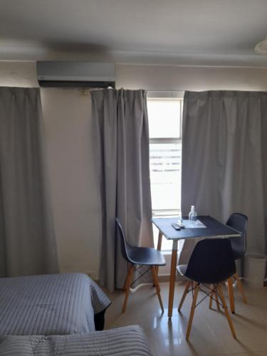 a room with a table and chairs and a window at Departamento Peatonal in Paraná