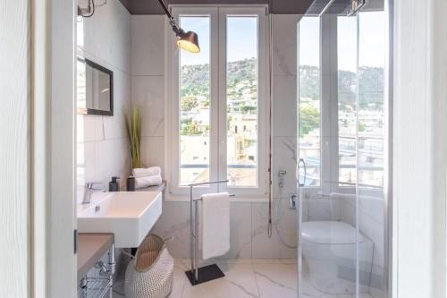 une salle de bain blanche avec un lavabo et une douche dans l'établissement #24 Marie-Claire Suite Sea view/balcony/AC/5min port, à Villefranche-sur-Mer