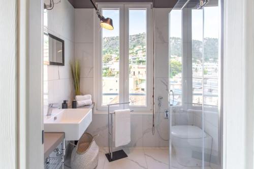 a white bathroom with a sink and a shower at #24 Marie-Claire Suite Sea view/balcony/AC/5min port in Villefranche-sur-Mer