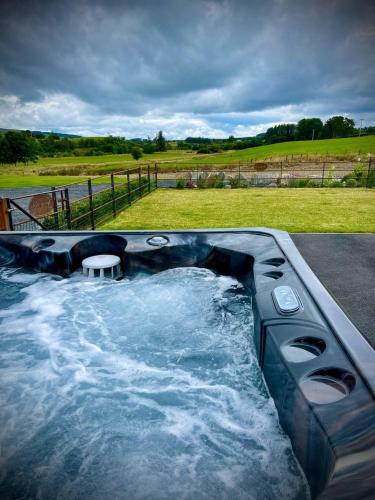 a jacuzzi tub with a table in the middle at Daisy in Rhayader