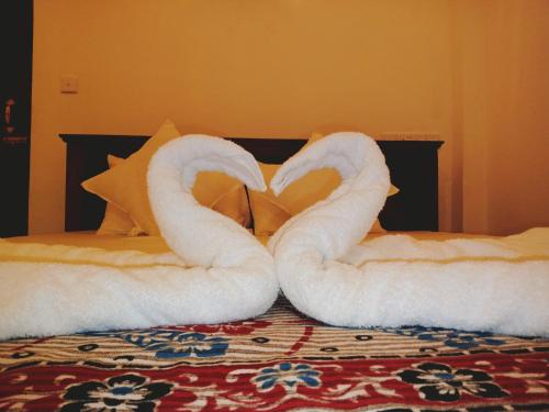 two towels shaped like swans sitting on a bed at Surf View Point Ahangama in Ahangama