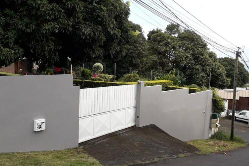 a white fence in front of a house at Charmant Studio Climatisé à Sainte Suzanne. in Sainte-Suzanne