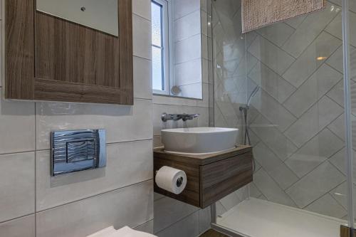 uma casa de banho com um lavatório e um chuveiro em Remarkable 4-Bedroom 3-Bathroom House em Pontefract