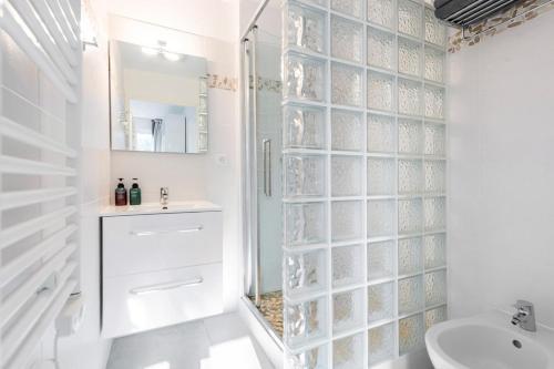 - une salle de bains blanche avec un mur en verre dans l'établissement Nice Flat 5 min walking from the sea, à Nice