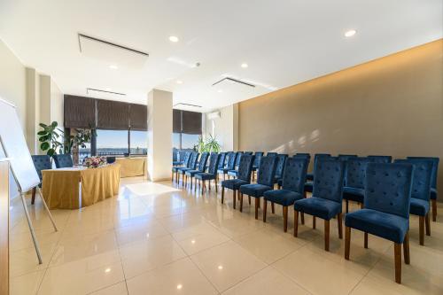 una sala conferenze con sedie blu e tavolo di Faleza Hotel by Vega a Galaţi