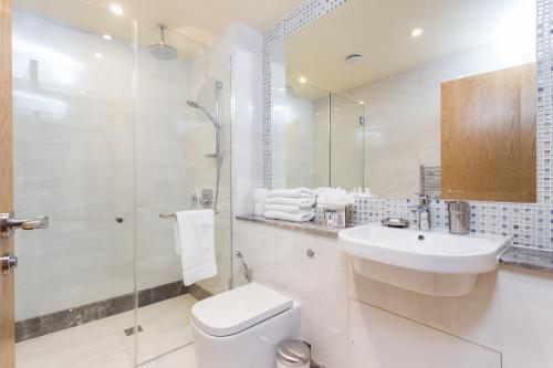 a bathroom with a toilet and a sink and a shower at Sanctum Belsize Road in London